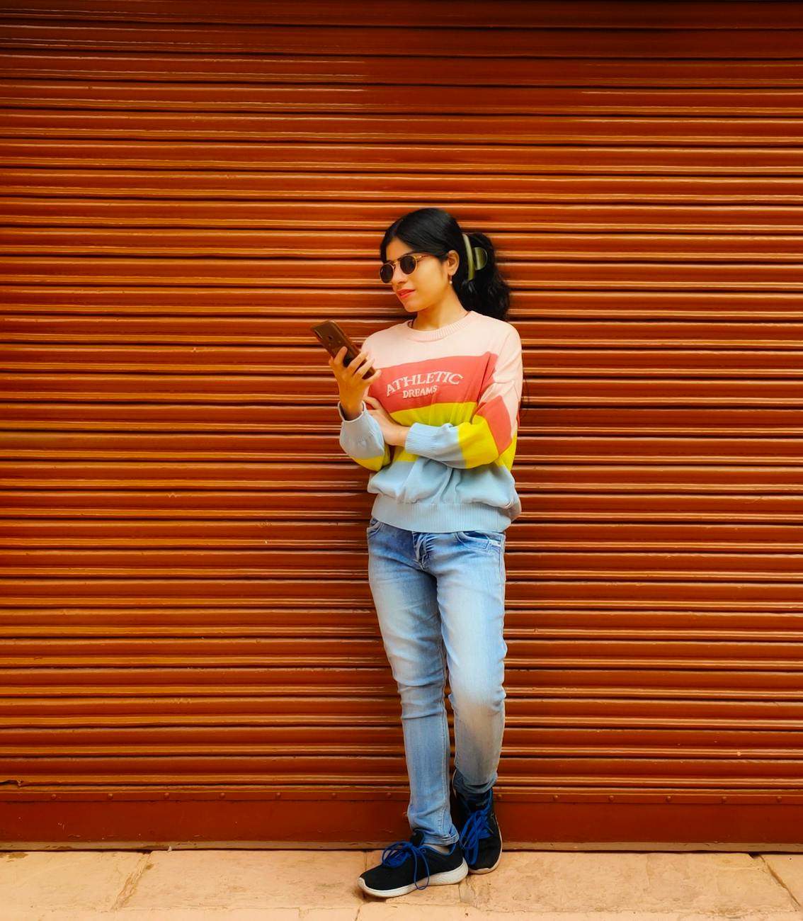 brunette woman in sunglasses standing with smartphone