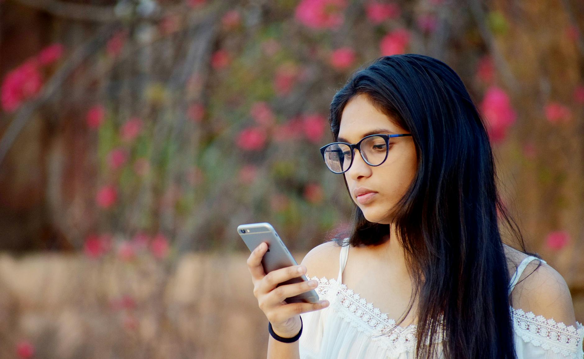 woman in white top using a phone