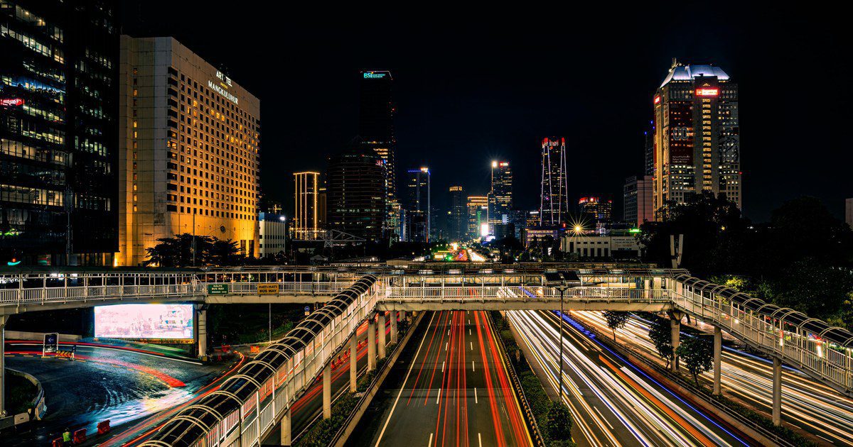 Long exposure night shot capturing Jakarta's vibrant skyline and bustling traffic.