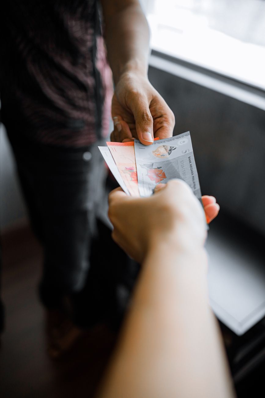 close up of a person handing money to another person